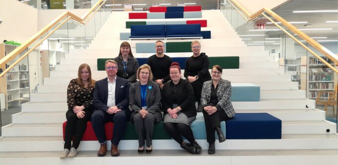 Ihmisiä istimassa portailla.