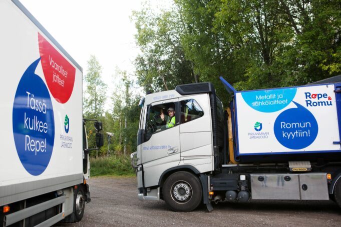 Kaksi kuorma-autoa pysäköitynä puiden varjoon.